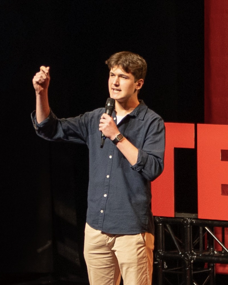 Ethan Buzza speaking on the TEDx stage